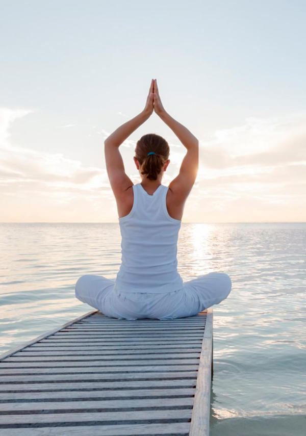 Young woman standing by the sea, embracing wellness and natural living